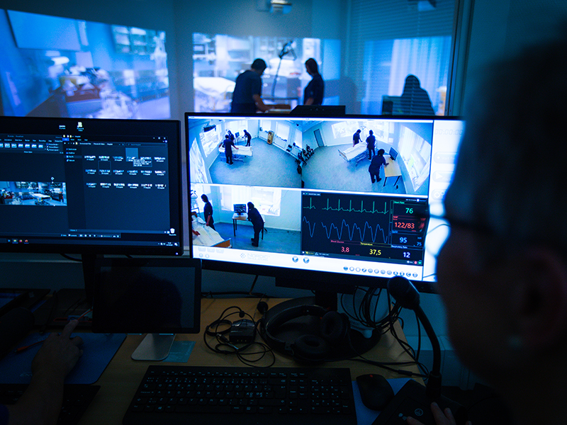Lärare övervakar monitorer i simuleringsrum